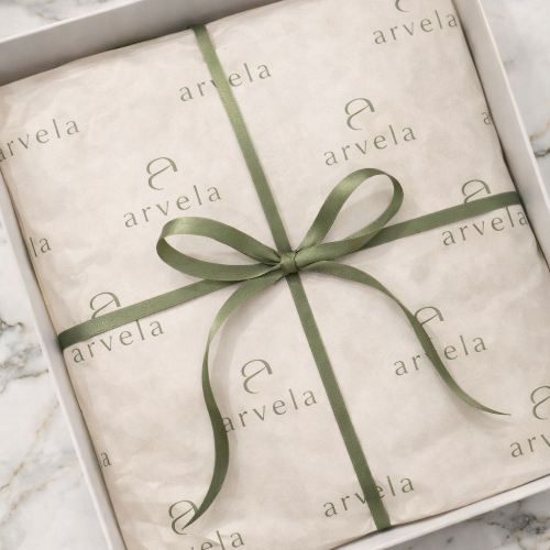 white jewellery packaging open with arvela logo and green ribbon representing a clean and minimalist jewellery packaging that considered the environment